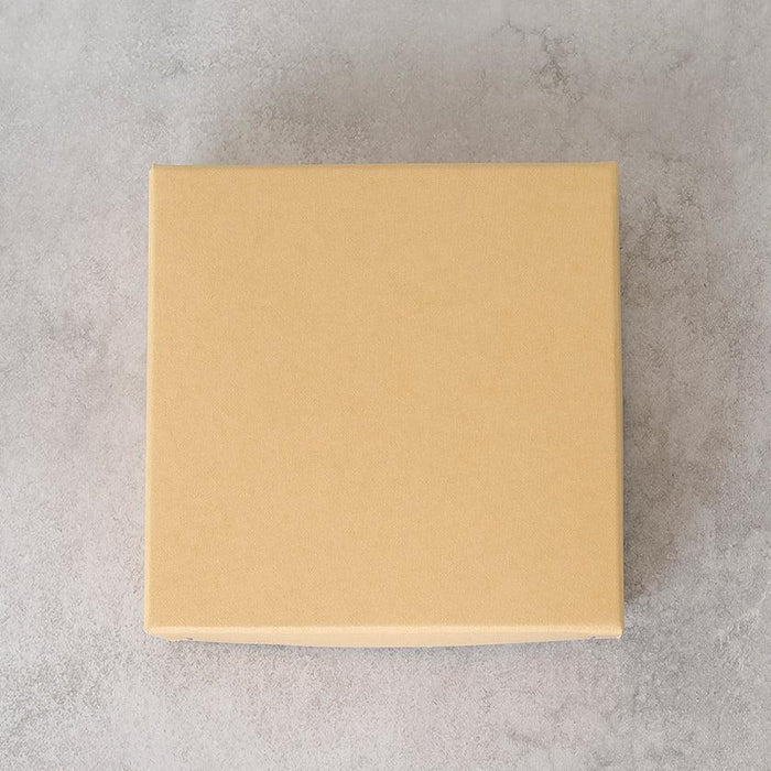 Plain beige gift box packaging on a gray surface