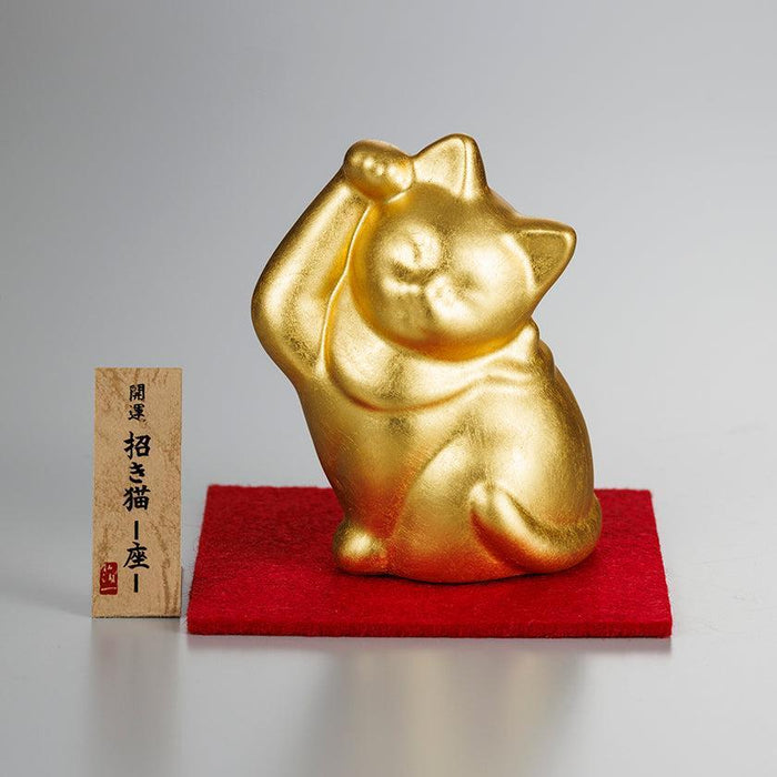 Gold maneki neko lucky cat figurine with raised paw on red mat | Kanazawa gold leaf, Hakuichi