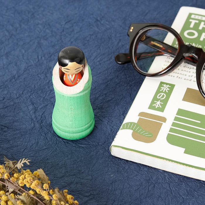 Princess Kaguya kokeshi wooden doll in green bamboo styling on blue surface | Tsuchiyu, Fukushima, Akihiro Konno