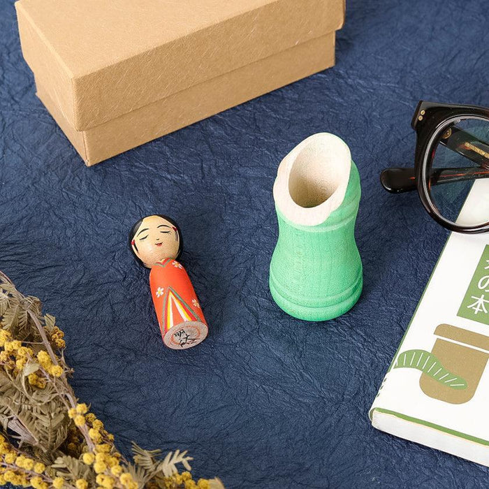 Princess Kaguya kokeshi wooden doll with green bamboo vessel on navy surface | Tsuchiyu, Fukushima, Akihiro Konno