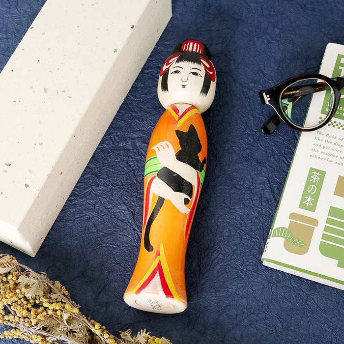 Taisho-style kokeshi wooden doll with black cat motif in orange kimono | Tsuchiyu, Fukushima, Akihiro Konno
