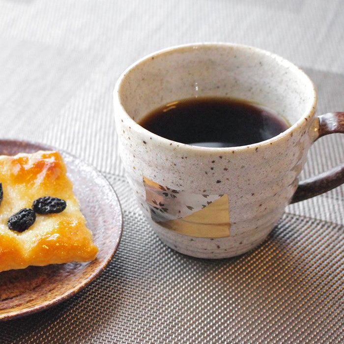 Japanese pottery coffee cup and saucer set with Kanazawa gold leaf motif, filled with black coffee | Hakuichi, Kanazawa