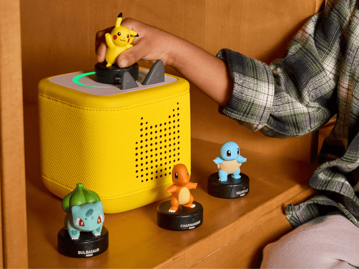 child playing with a lightning yellow toniebox 2 and four pokemon tonies