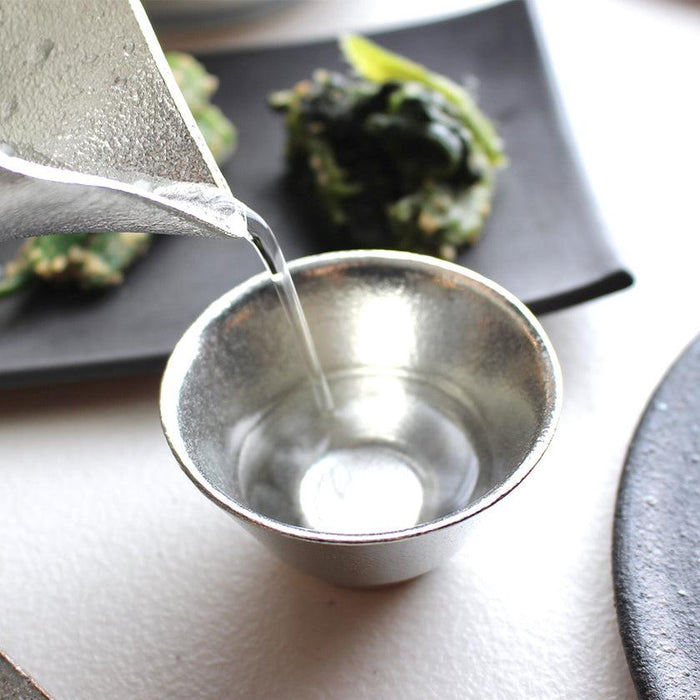 Sake being poured into a tin sake cup | Takaoka casting, Nousaku