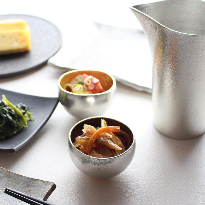 Tin and gold leaf sake cups with matching pitcher styled in a Japanese table setting | Nousaku, Takaoka