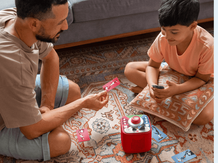 man and child playing with Tonieplay-Stadium Showdown and a red toniebox 2